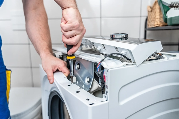 Technician checking refrigerator temperature settings in a Huntsville residential kitchen