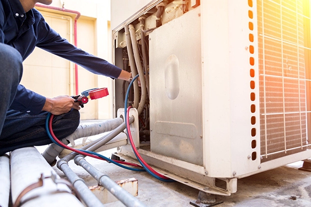 Open furnace cabinet with technician examining blower motor and wiring harness